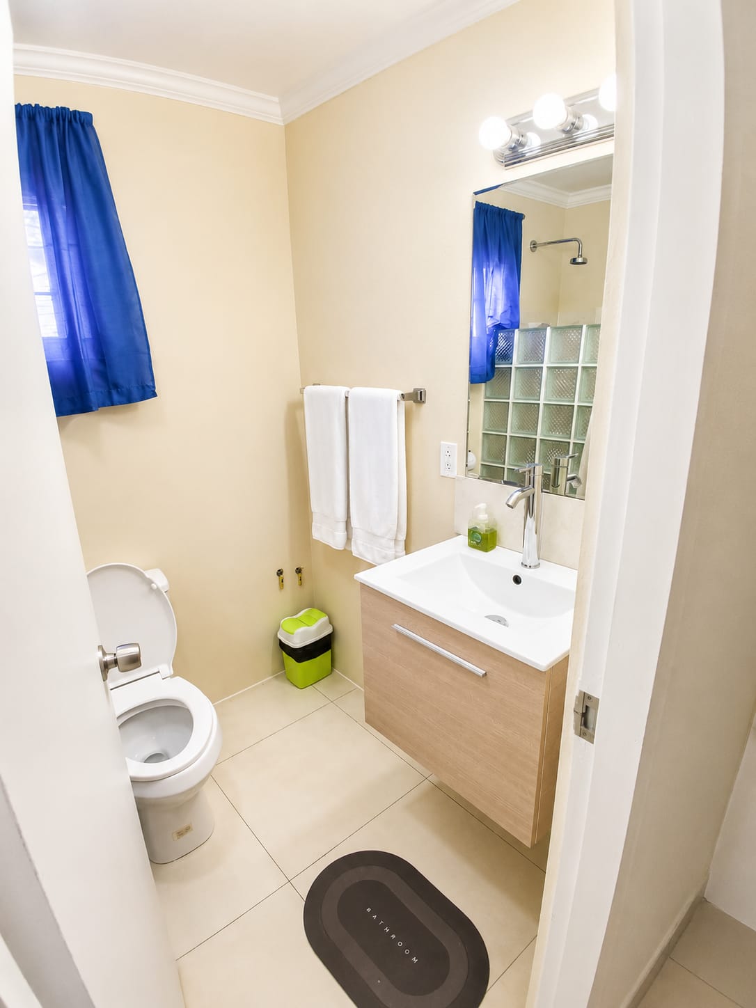Compact bathroom with blue curtains and modern vanity